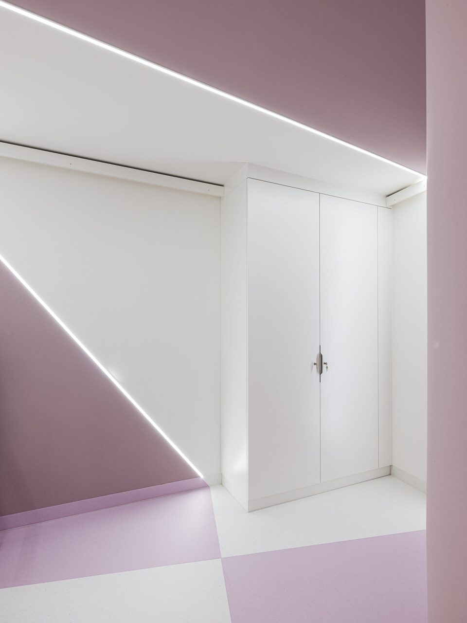 Weiße Einbautür in roséfarbener Wand, die Lichtlinie läuft als Diagonale über die Wandfläche bis zum Boden