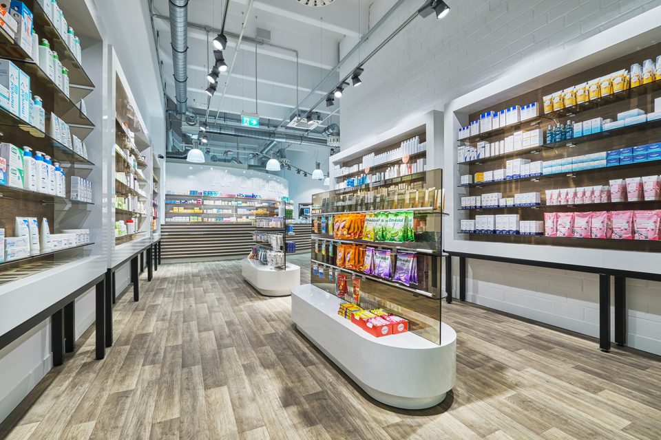 Freiwahlregale der Barbara-Apotheke Ingolstadt mit Pflegeprodukten vor hellen Holzrückwänden