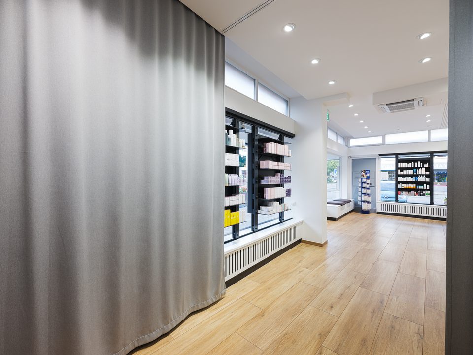 Verkaufsraum der Engel-Apotheke Planegg mit Vorhang, Tresen und warmer Holzverkleidung
