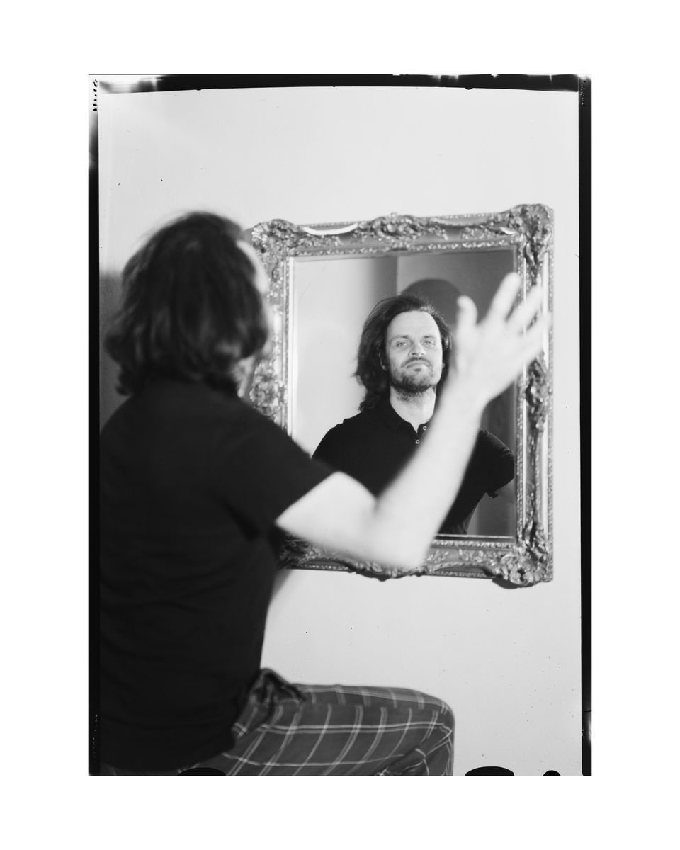 Porträt von Simon über eine Spiegelung fotografiert, analoges Großbild-Porträt