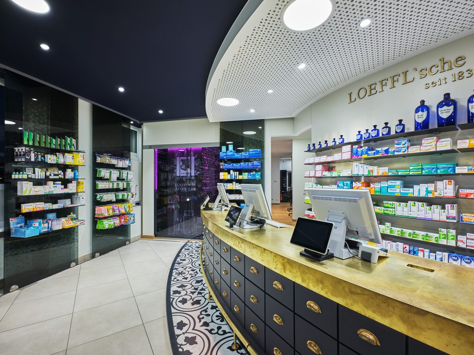 Linker Offizinbereich der Löffl’schen Apotheke mit Sichtwahl und dunkler Decke