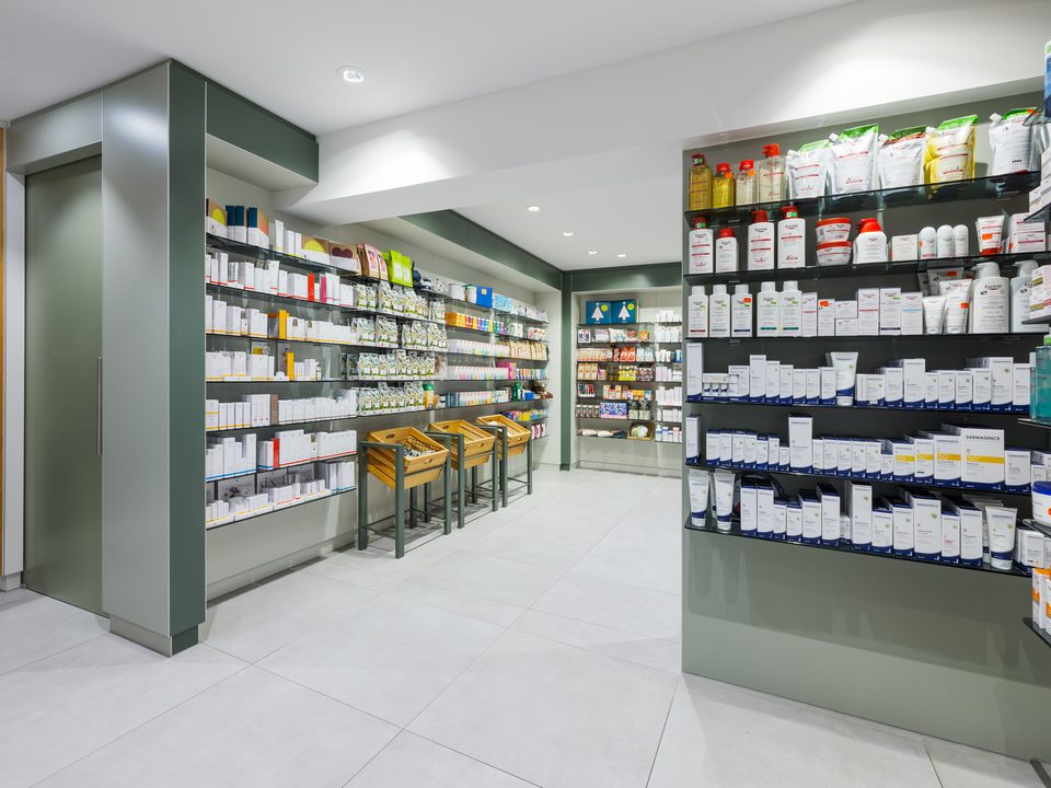 Freiwahl der Marienapotheke Schongau mit salbeigrünen Wandscheiben und Glasregalen voller Pflegeprodukte